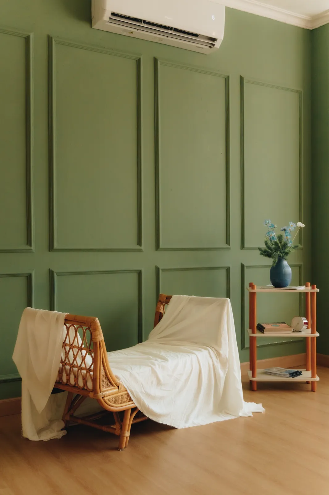 Sauropod Space: green panelled wall with a rattan lounge chair